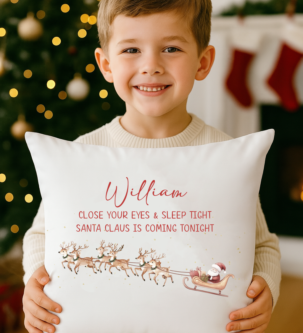 Child hugging Santa is Coming Tonight personalised cushion by Christmas tree.