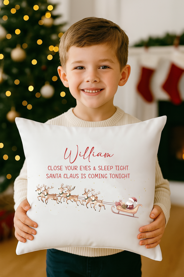 Child hugging Santa is Coming Tonight personalised cushion by Christmas tree.