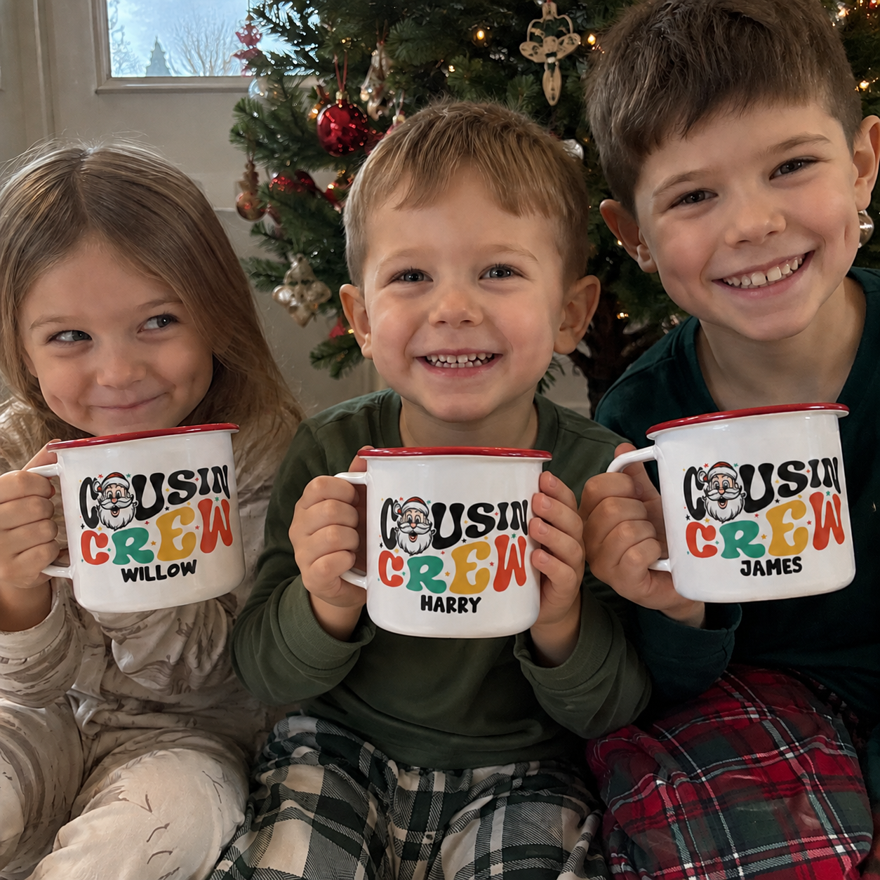 Three cousins holding personalised Santa Cousin Crew enamel mugs in front of the Christmas tree - The Custom Co
