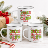 Three 2026 Christmas Crew personalised enamel mugs stacked with pine, candy canes and a gift