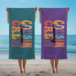 Personalised 'Cousin Crew' towels on a beach.