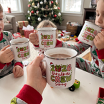 Children drinking hot chocolate from personalised Christmas Crew enamel mugs on Christmas morning