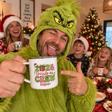 Dad in a green Grinch onesie holding his personalised 2026 Christmas Crew enamel mug - The Custom Co