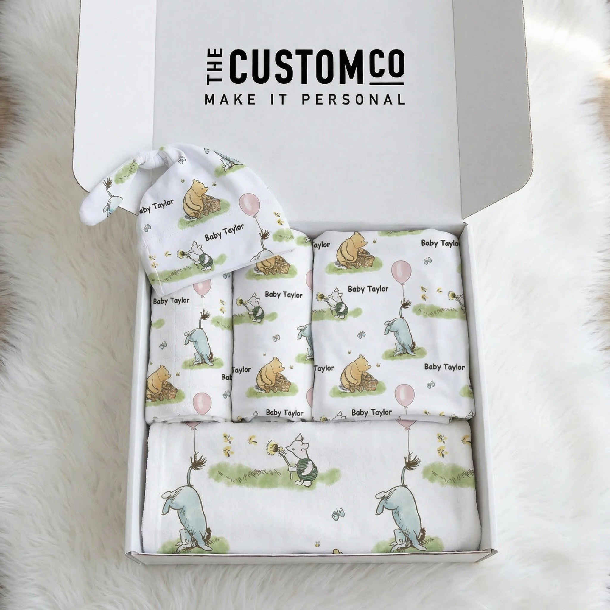 Personalised newborn essentials gift bundle with minky blanket, jersey swaddle, beanie, muslin swaddle, and 6-in-1 nursing cover baby box